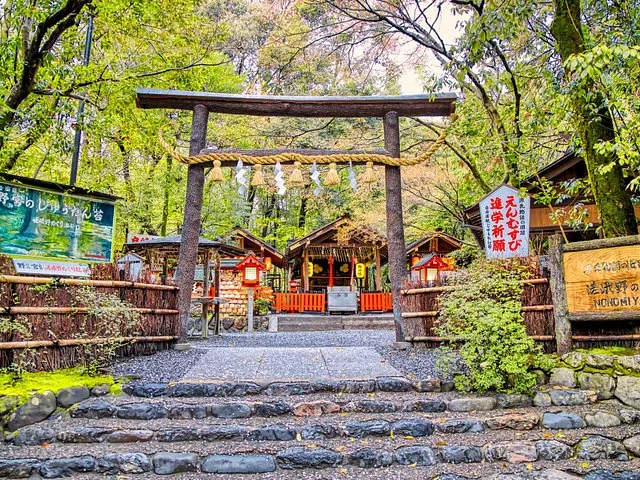 A traditional torii gate at Nonomiya Shrine surrounded by lush green trees